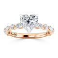 Rose gold ring with a heart-shaped diamond center and marquise accent diamonds along the band.