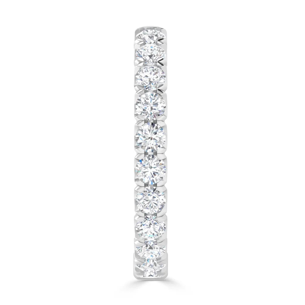 A white gold ring with a row of round, sparkling diamonds set closely together in a straight line.
