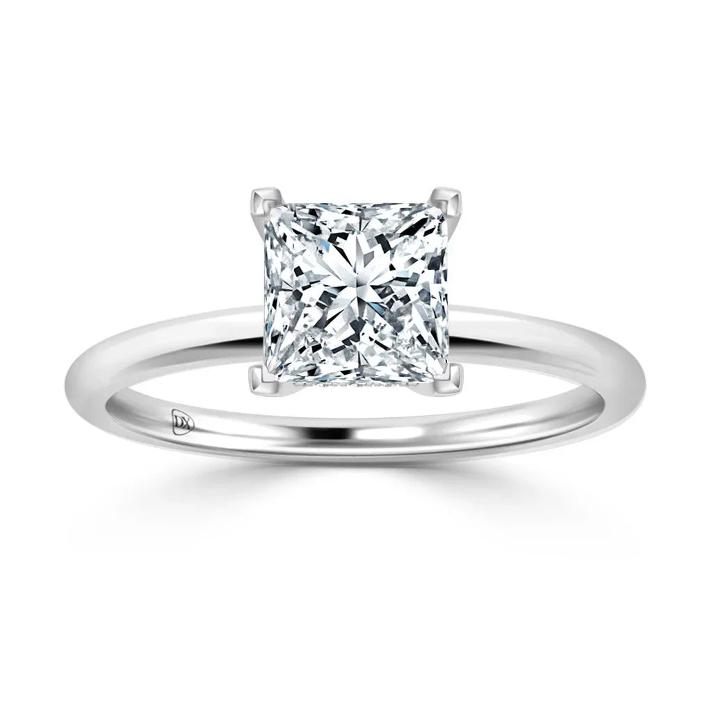 A solitaire ring with a princess-cut diamond set on a simple, polished white metal band.