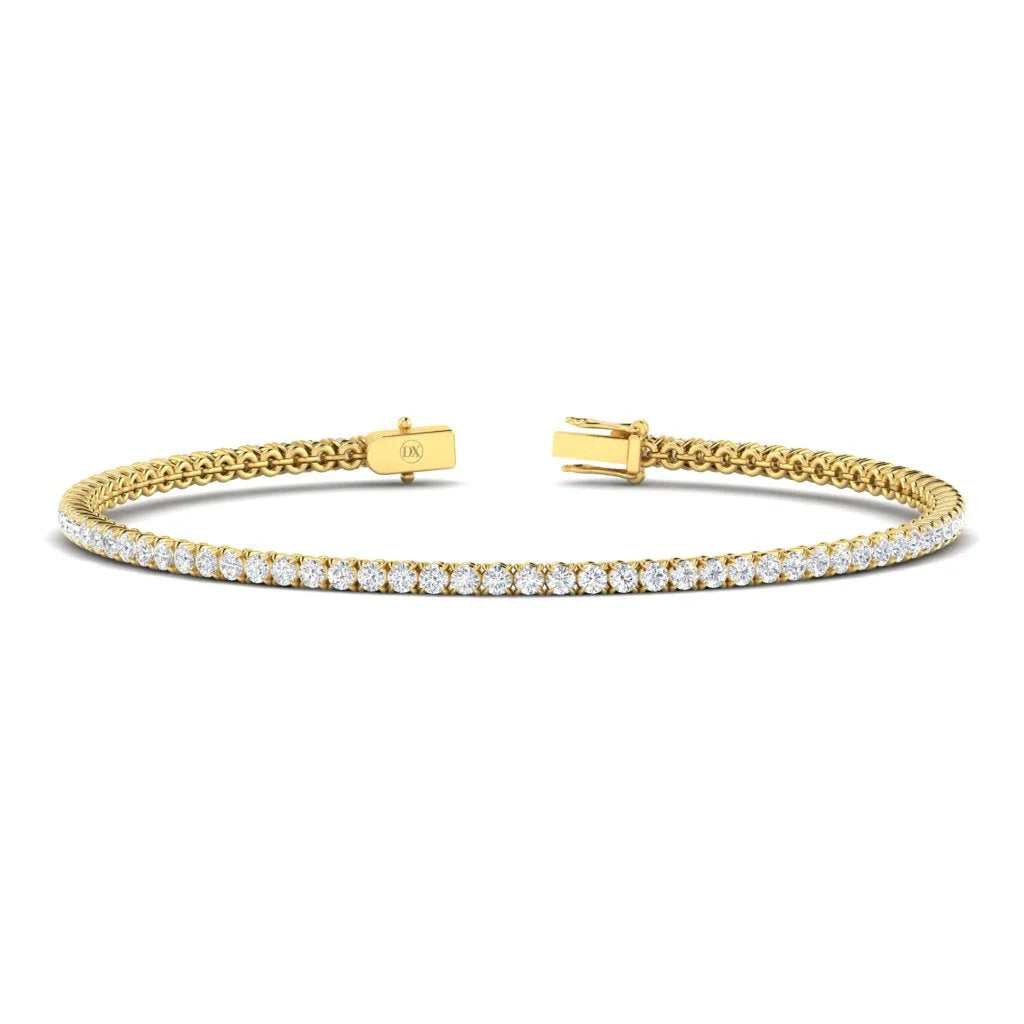 A gold tennis bracelet with a single row of round white diamonds and a box clasp closure.