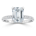 Emerald-cut diamond ring with a pavé diamond band, set in white gold, displayed on a white background.