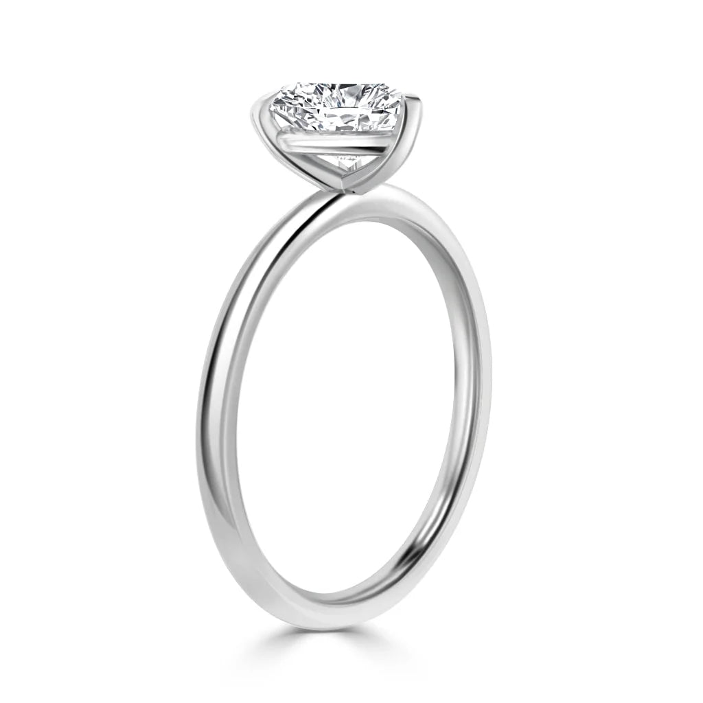 A solitaire diamond ring with a slim white gold band and a round diamond set in a minimalist prong setting.