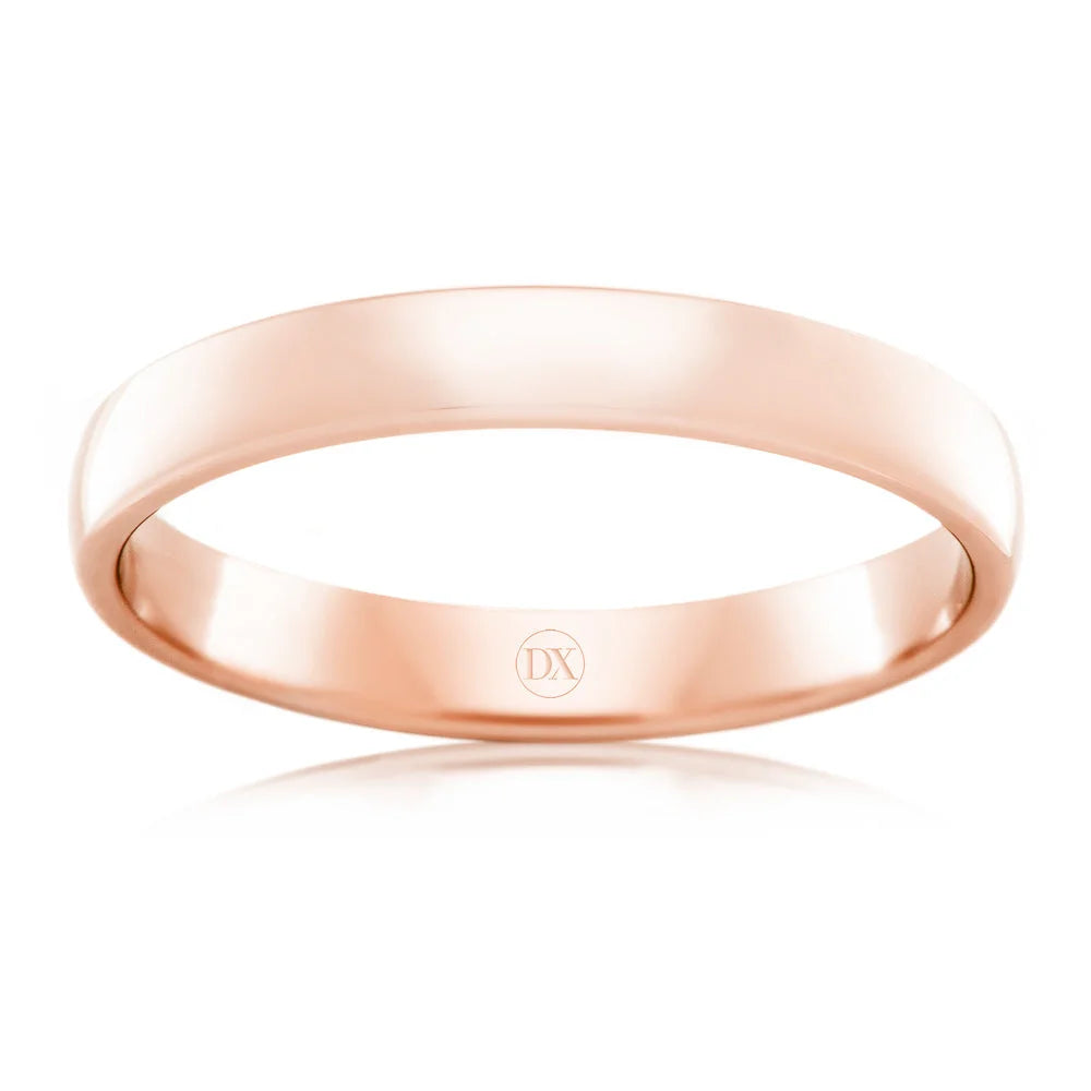 A simple, polished rose gold ring with a smooth surface and the engraving DX inside the band.