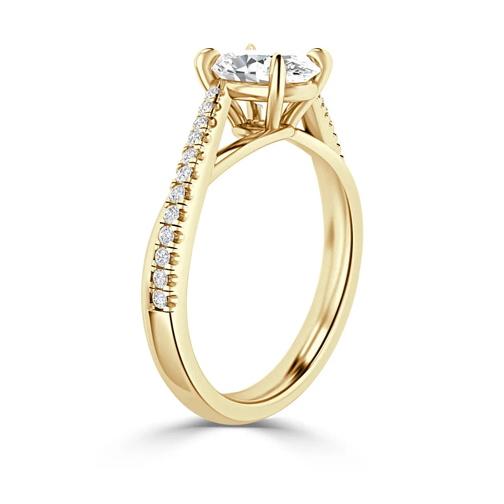 Gold engagement ring with a round center diamond and small diamonds set along the band, shown side view.