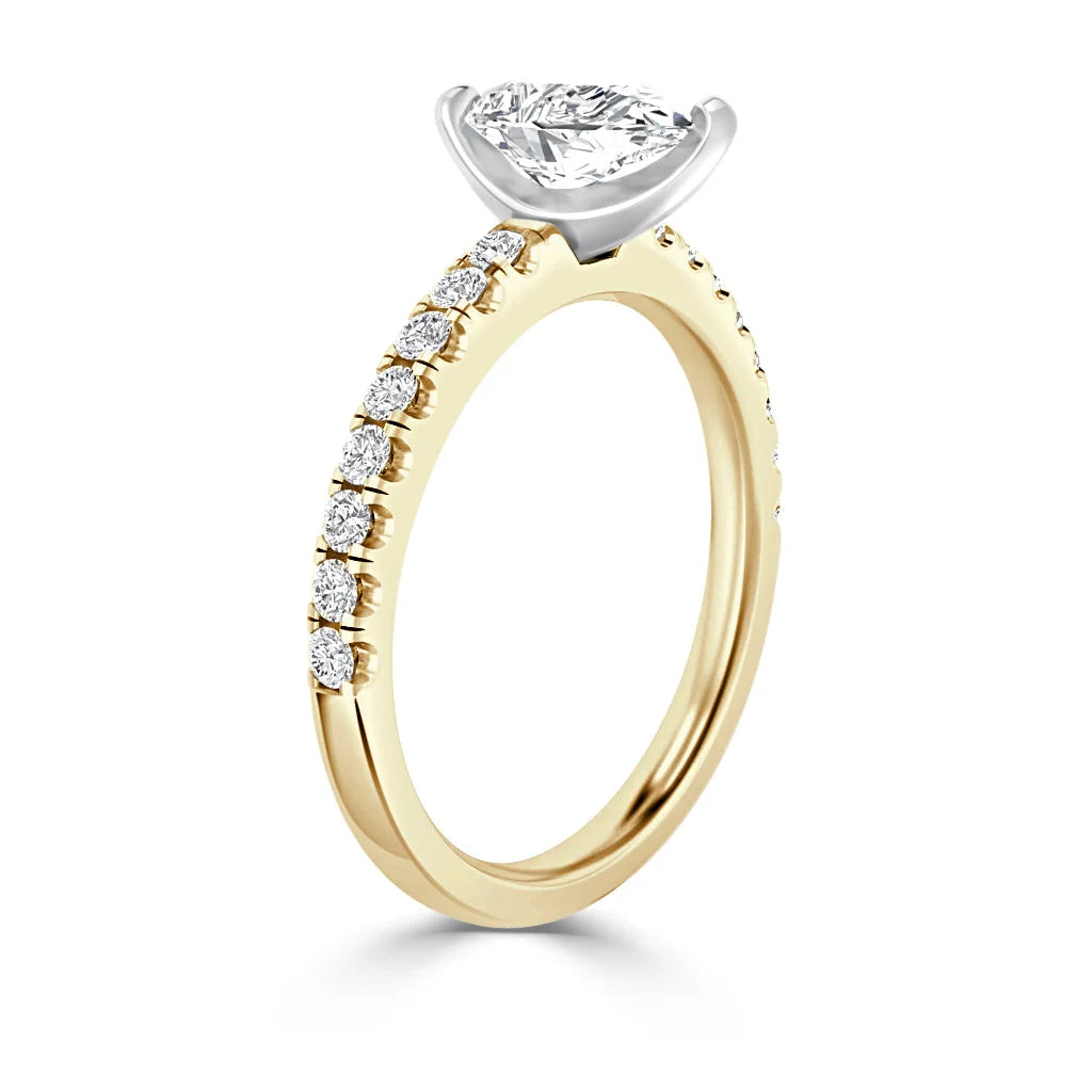 Gold ring with a marquise diamond center stone and small diamonds set along the upper half of the band.