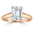 Emerald-cut diamond solitaire ring with a rose gold band, shown on a white background.