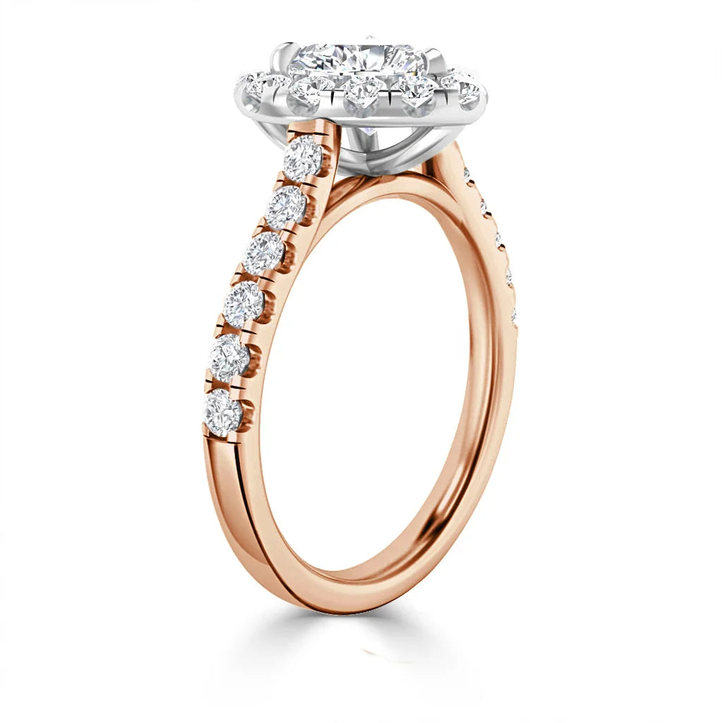 Rose gold engagement ring with round diamond halo and diamond accents on the band, set against a white background.