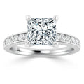 Platinum ring with a princess-cut diamond center stone and smaller diamonds set along the band.