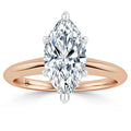 A marquise-cut diamond solitaire ring with a rose gold band and four prongs holding the diamond.