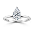 A silver ring with a large, pear-shaped diamond solitaire set on a simple, thin band.