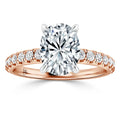 Rose gold ring with an oval-cut diamond center and small round diamonds along the band on a white background.