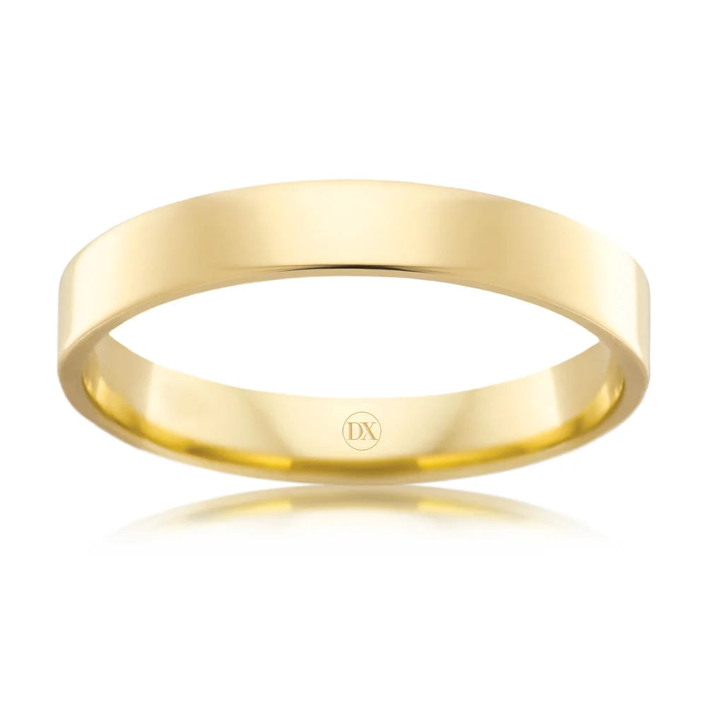 A plain, polished yellow gold ring with a flat profile and a small DX engraving inside the band.