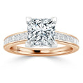 Rose gold ring with a large princess-cut diamond and smaller diamonds set along the band.