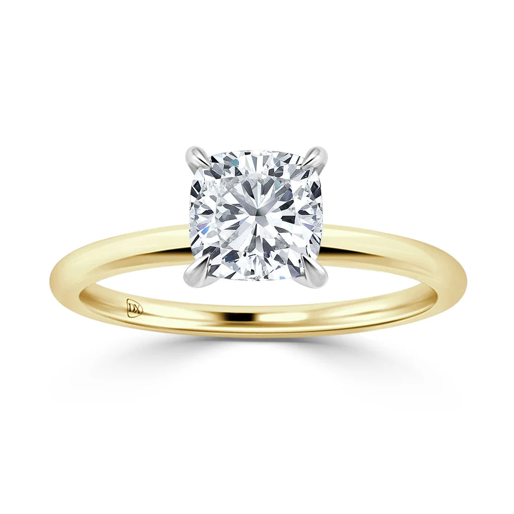 A cushion-cut diamond solitaire ring with a yellow gold band and four prongs, on a white background.