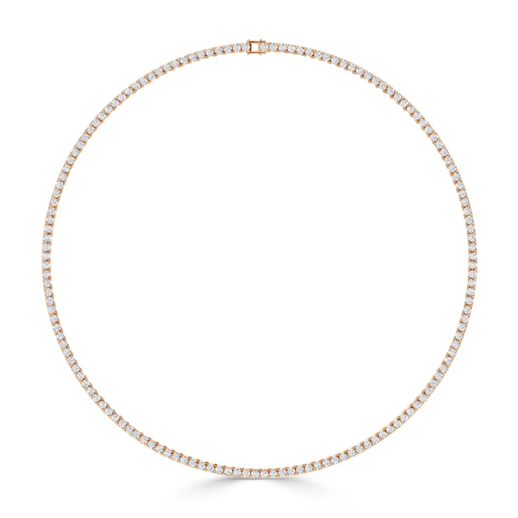 A delicate gold tennis necklace set with small, round white diamonds in a continuous circle, clasp at top.