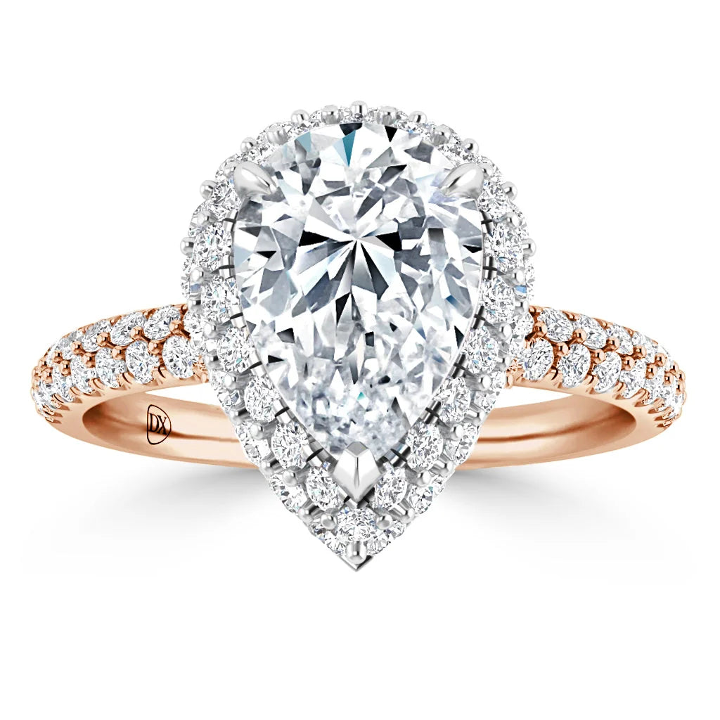 A pear-shaped diamond ring with a halo of smaller diamonds on a rose gold band, set with pavé diamonds.