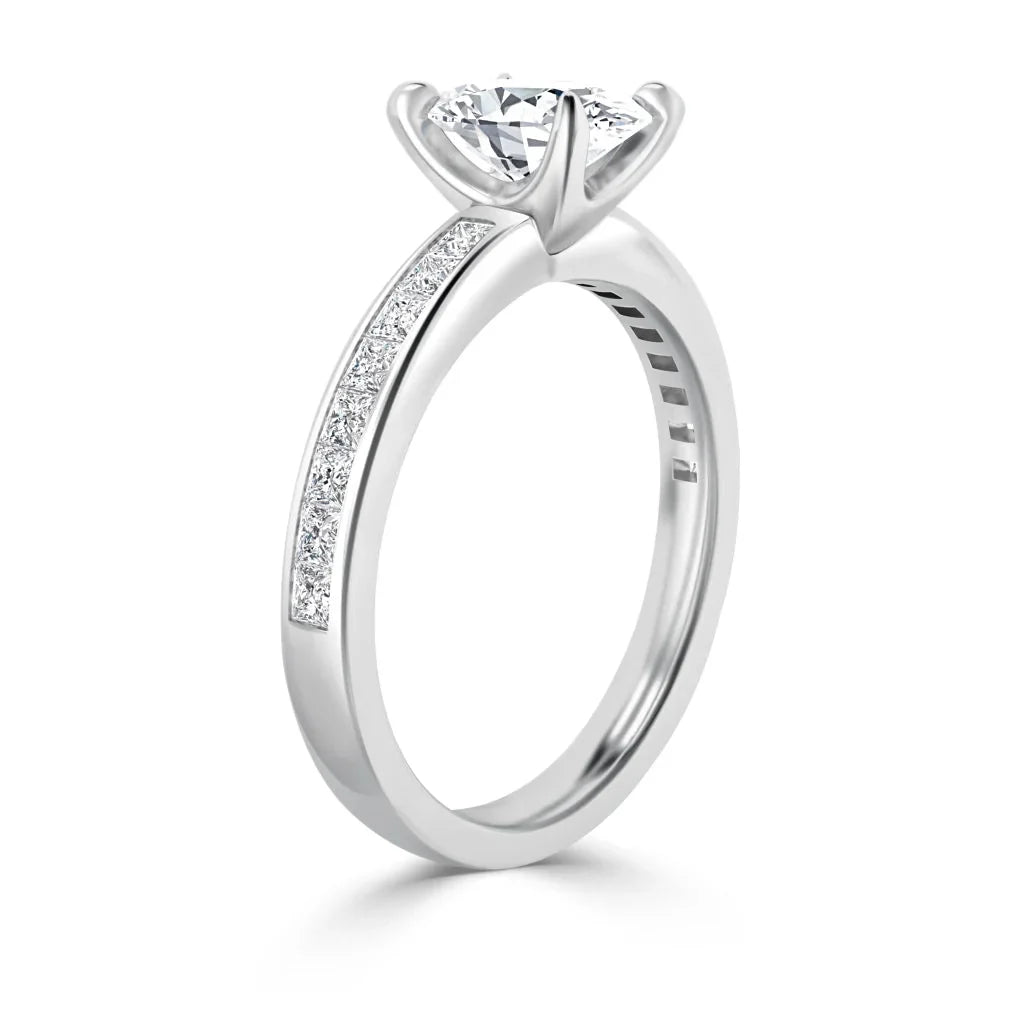 A silver engagement ring with a large round diamond and small diamonds embedded along the band.