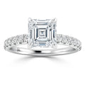 A white gold ring with an Asscher-cut diamond center and round diamonds on the band.
