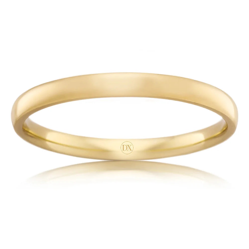 A simple, polished yellow gold band ring with a small DX logo engraved on the inside surface.