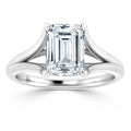 Emerald-cut diamond solitaire ring with split-shank platinum band on a white background.