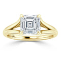 A gold ring with a split shank band and a large square emerald-cut diamond in a four-prong setting.