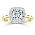 Gold ring with a central round diamond, surrounded by a cushion-shaped halo of smaller diamonds.