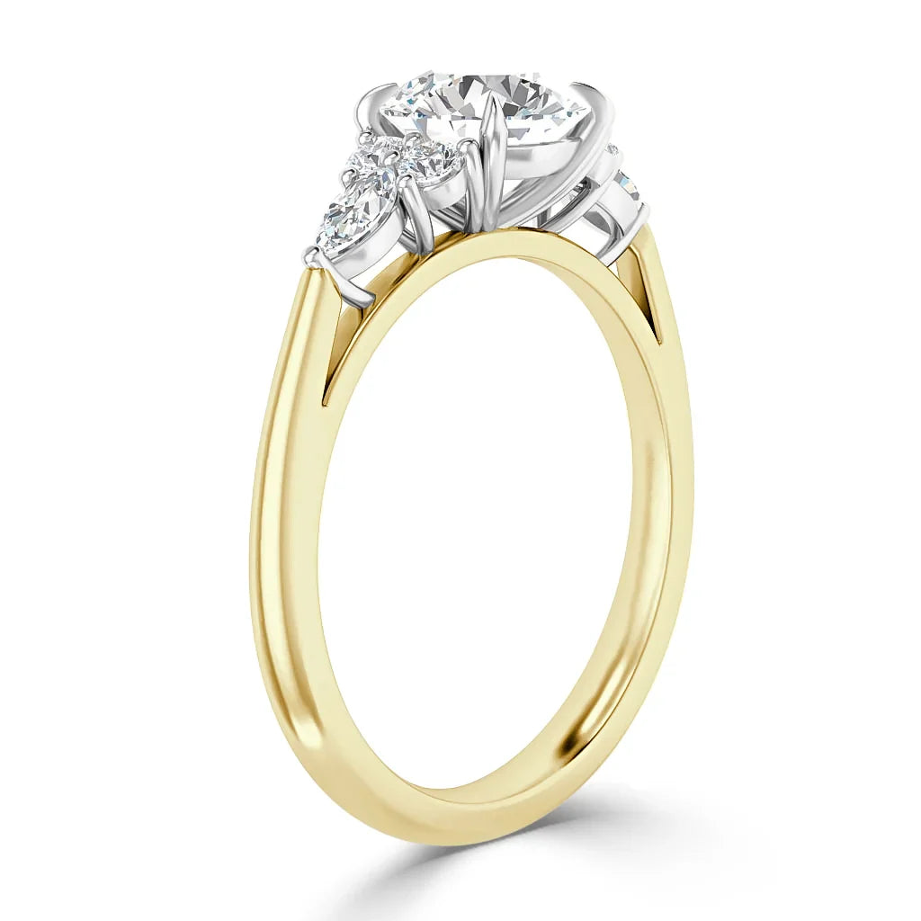 Gold ring with a large round diamond center stone and two smaller side diamonds in a prong setting.