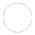A thin gold tennis necklace with small, evenly spaced diamonds in a full circle on a white background.