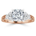 Rose gold ring with a large center diamond flanked by three smaller diamonds on each side, ornate band detailing.