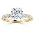 A gold ring with a large cushion-cut diamond center and smaller diamonds on the band.