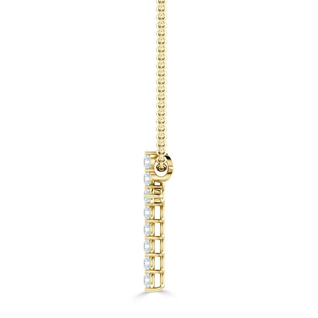 Side view of a gold pendant necklace with a row of small white gemstones on a beaded gold chain.