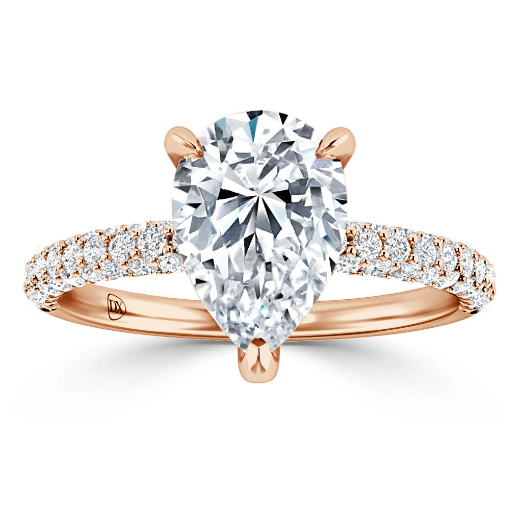A pear-shaped diamond ring with a rose gold band, accented by small pavé diamonds along the band.