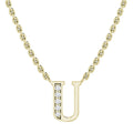Gold chain necklace with a U pendant, half-studded with small clear diamonds on the left side.