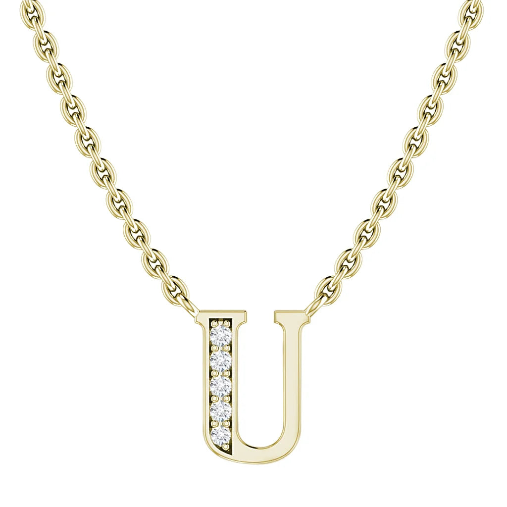 Gold chain necklace with a U pendant, half-studded with small clear diamonds on the left side.