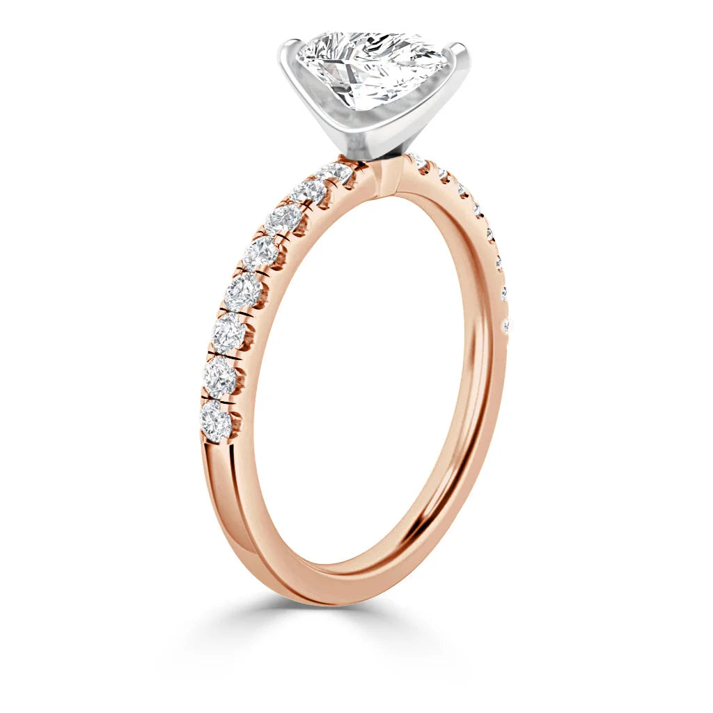 Rose gold ring with a large round diamond solitaire and small diamonds along the band, shown angled upright.