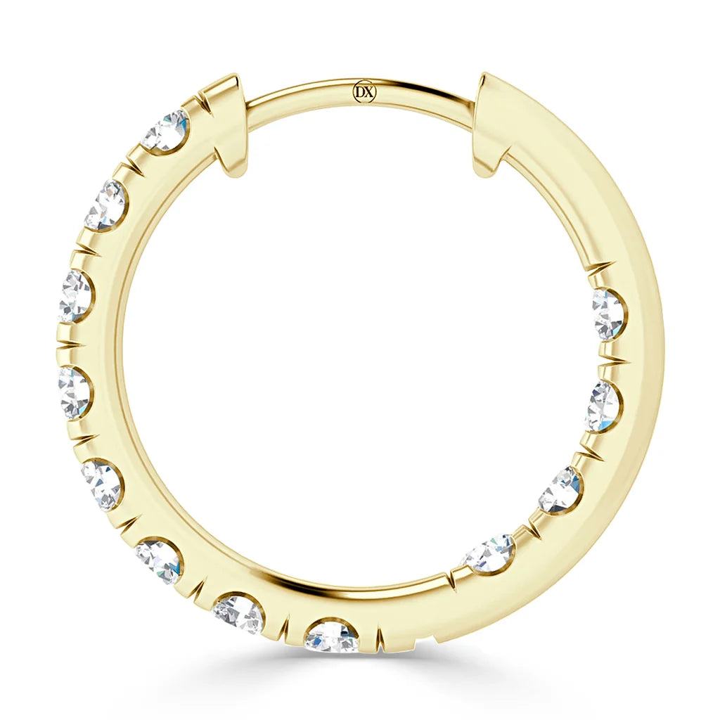 A gold hoop earring with evenly spaced, embedded clear gemstones around its outer edge.