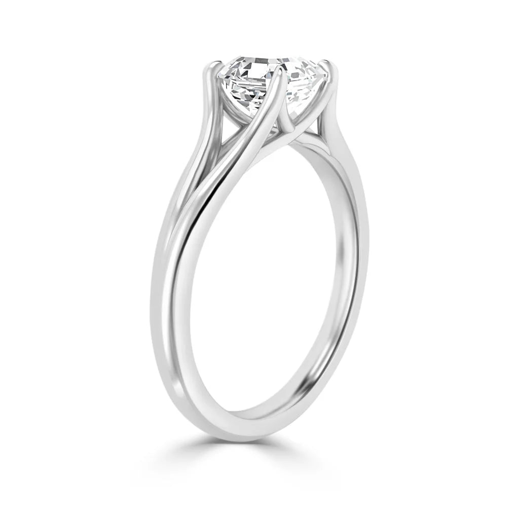 A white gold ring with a round solitaire diamond in a modern, four-prong twisted setting.