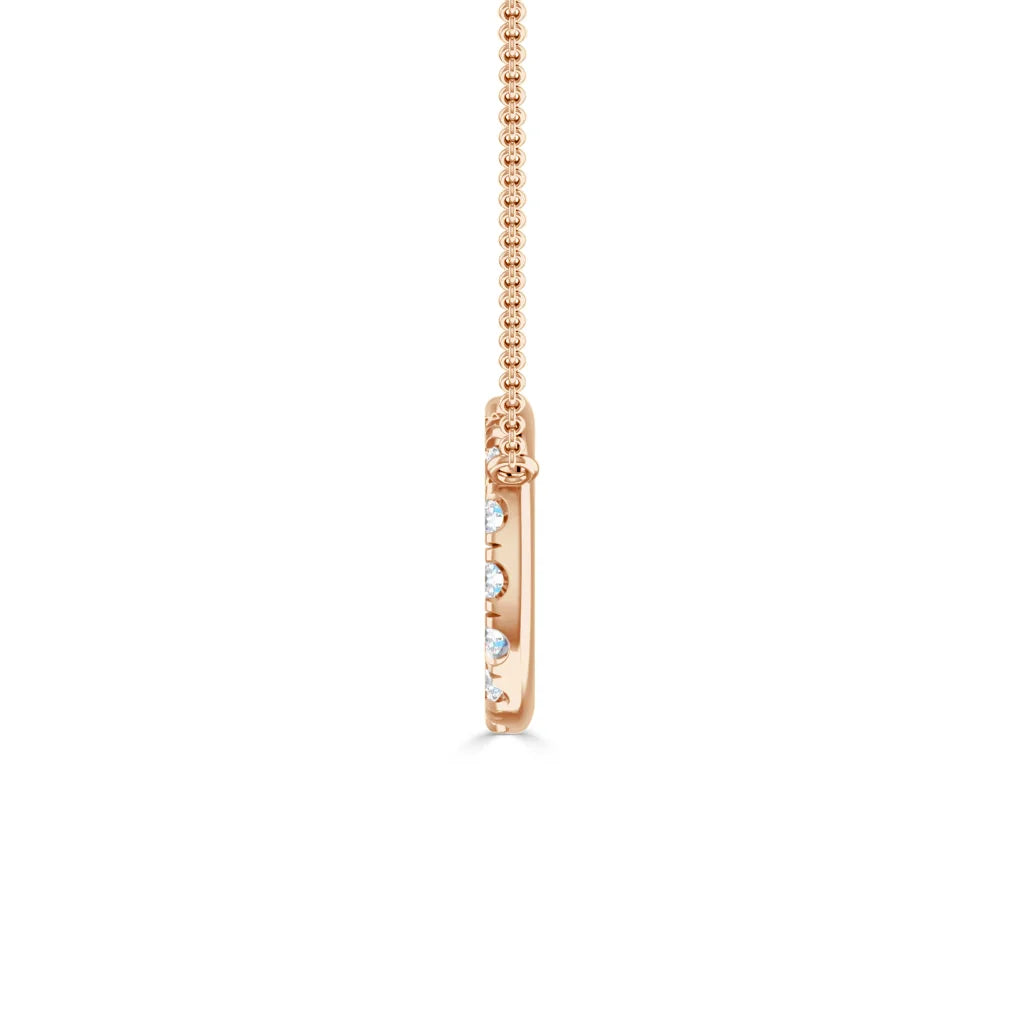 Side view of a rose gold pendant with embedded small diamonds on a delicate chain, against a white background.