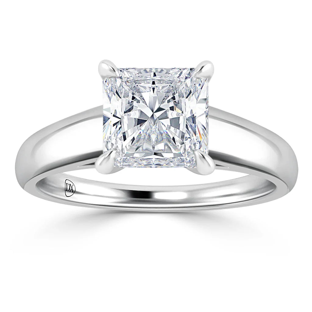 A silver band ring with a large, square-cut clear diamond held by four prongs at the center.