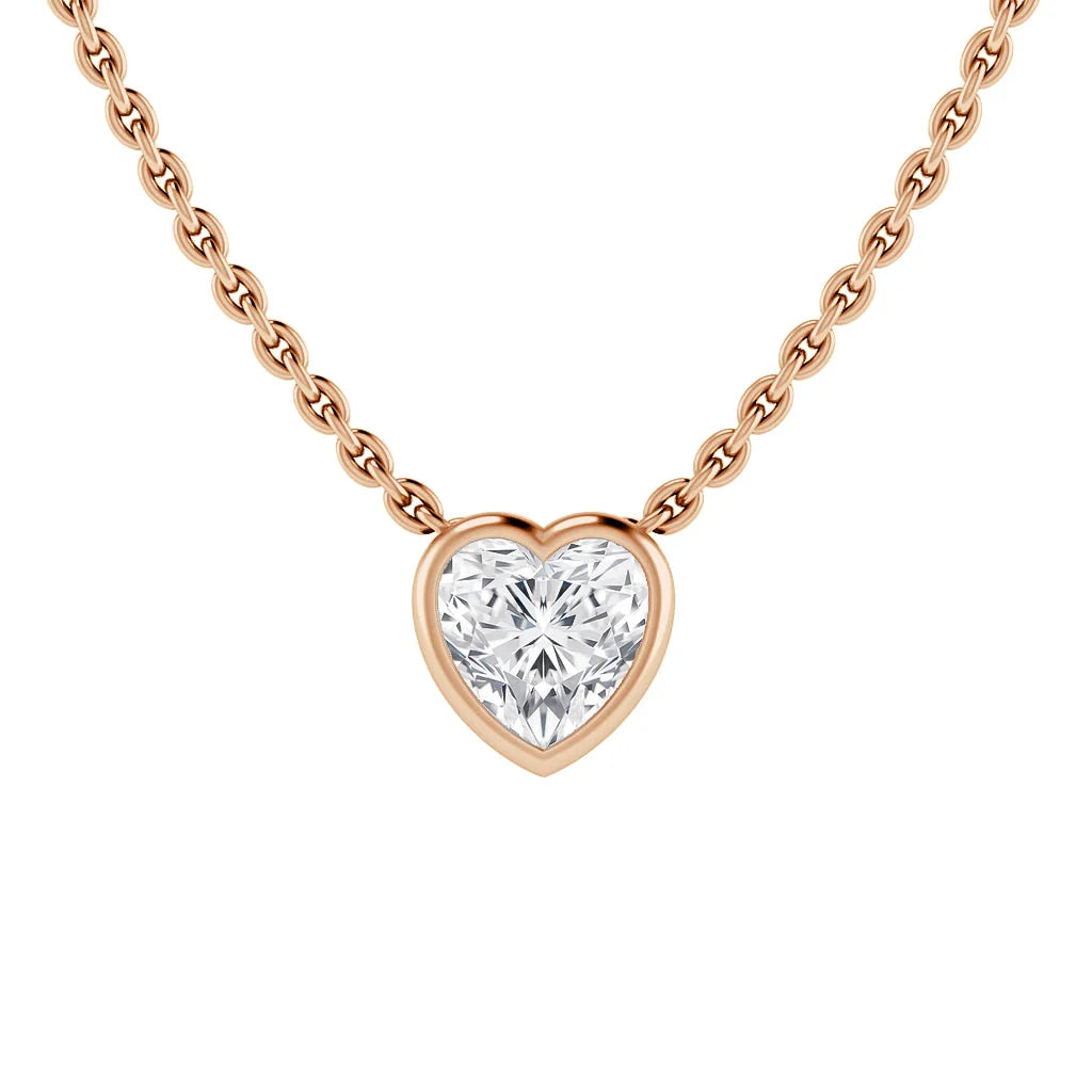 A gold chain necklace with a heart-shaped diamond pendant set in a gold bezel, on a white background.