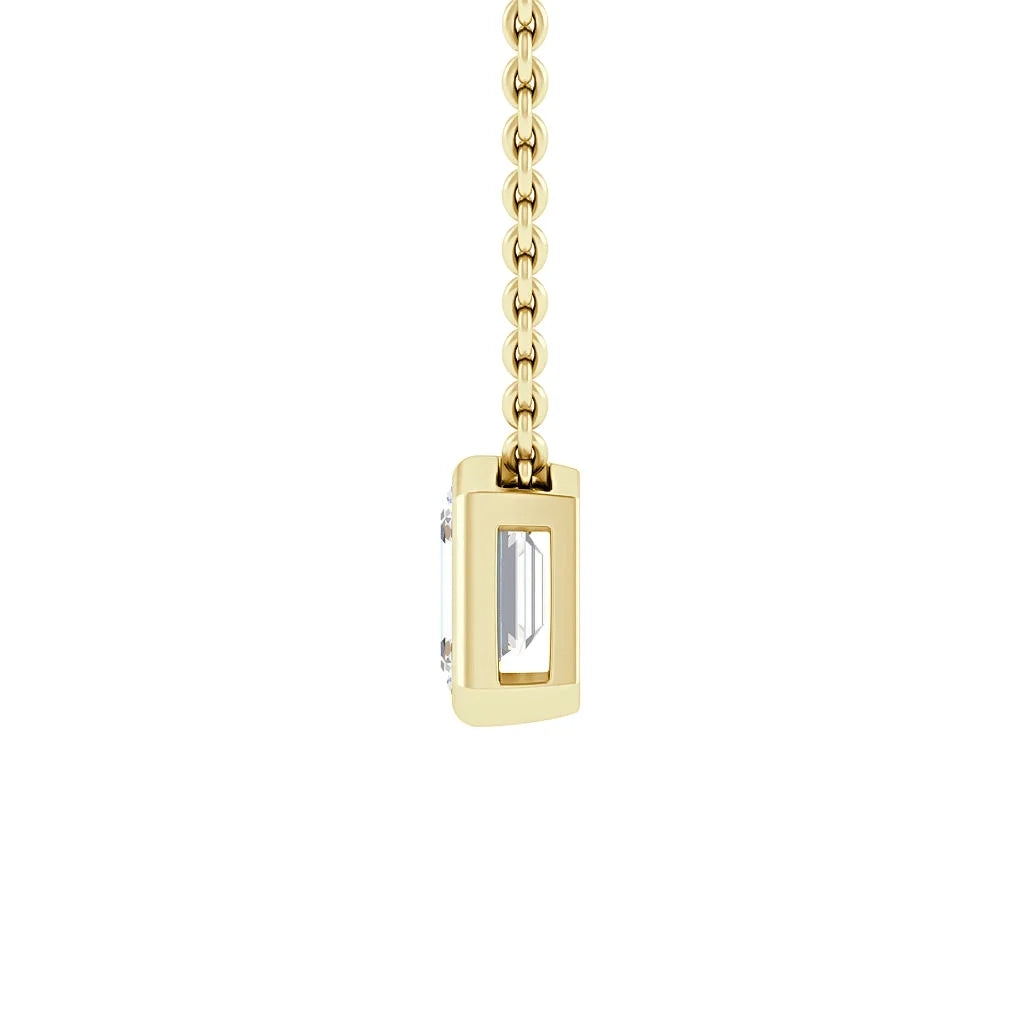 A gold chain necklace with a rectangular pendant holding a clear emerald-cut gemstone, shown from the side.