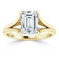 A gold ring with a split shank band, featuring a large emerald-cut diamond in a prong setting.