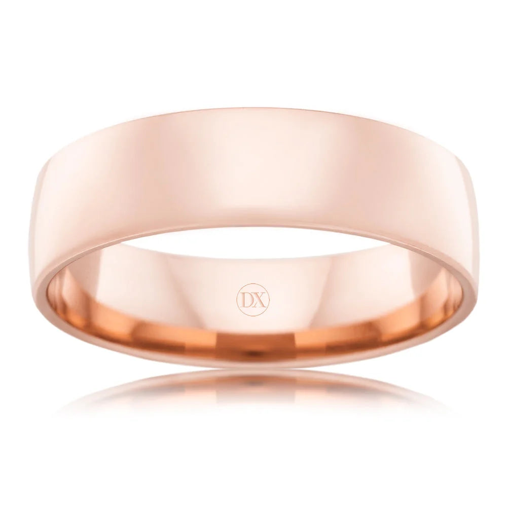 A simple, polished rose gold wedding band with a smooth surface and a subtle DX engraving inside.