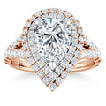 Rose gold ring with a large pear-shaped diamond, double halo, and split band encrusted with smaller diamonds.