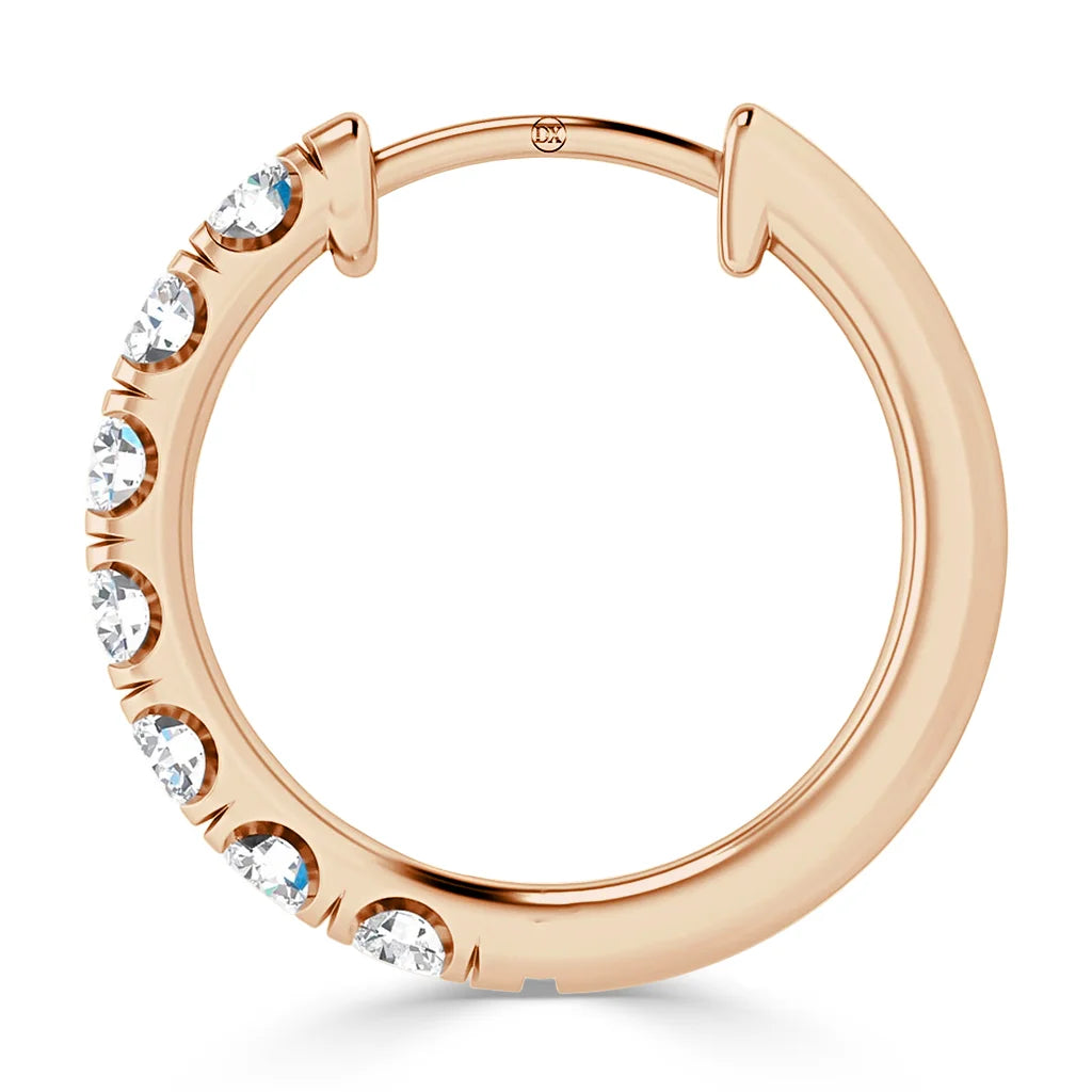 A rose gold hoop earring with seven round, sparkling diamonds set along one side.