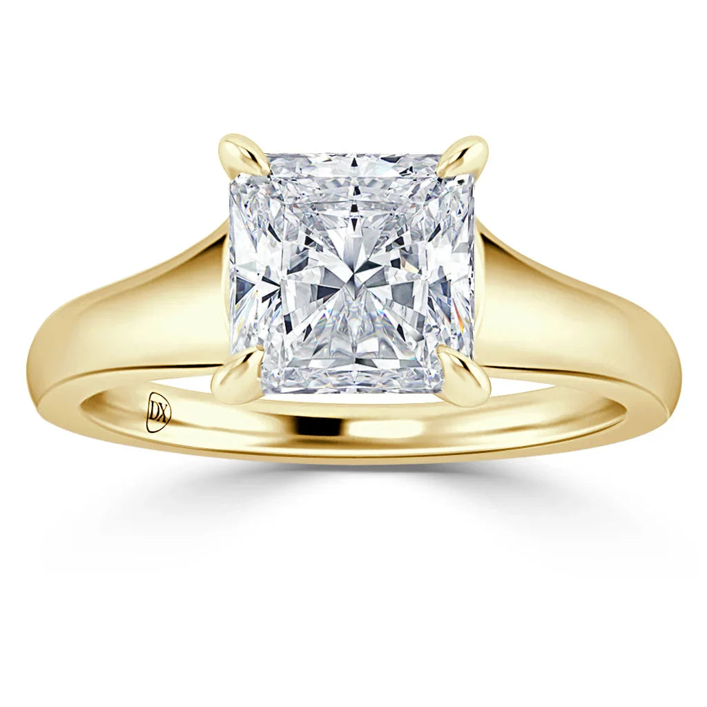 Gold ring with a large, square-cut diamond solitaire in a four-prong setting on a smooth band.