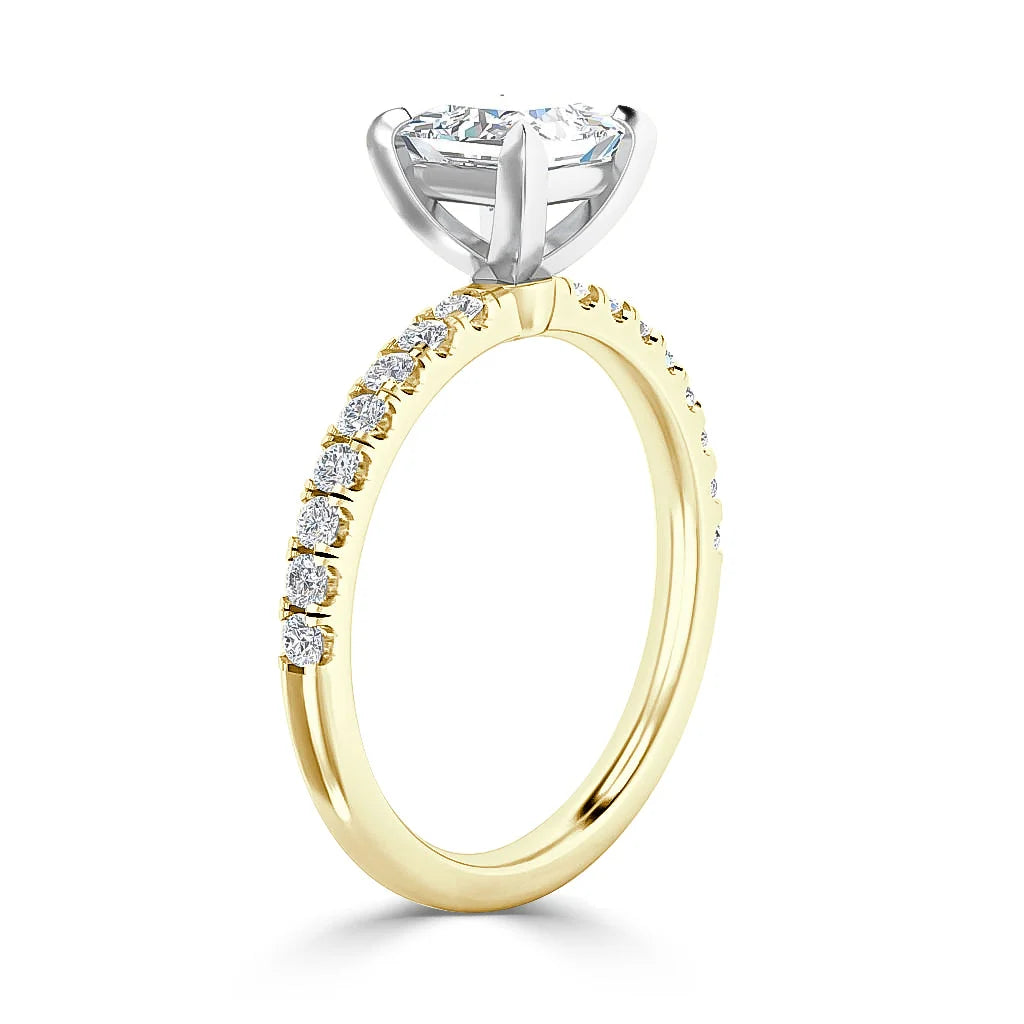A gold ring with small diamonds on the band and a large round diamond set in a white gold prong setting.