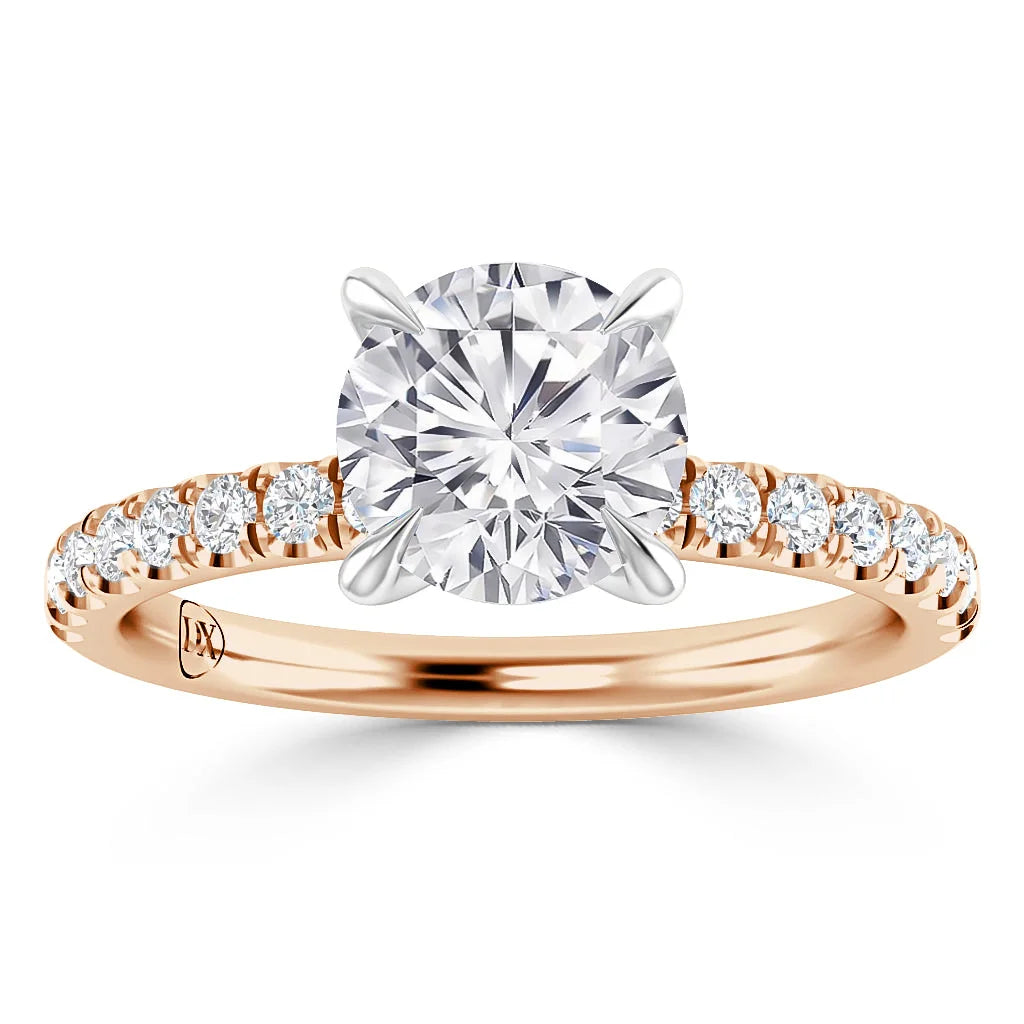 A rose gold ring with a large round diamond center and smaller diamonds along the band.