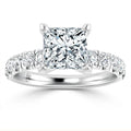 Platinum ring with a large princess-cut diamond center and smaller round diamonds on the band.