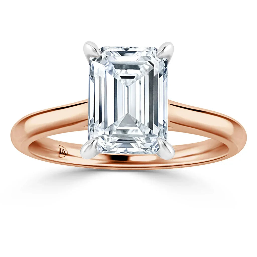 Emerald-cut diamond solitaire ring with a rose gold band and four-prong setting on a white background.